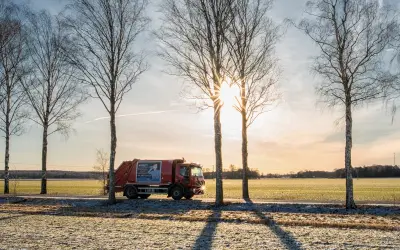 Lastbil på en väg kantad av träd